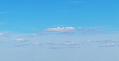Small cumulus white clouds in the blue sky