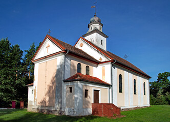 Fototapeta premium General view and architectural details of the Catholic church built in 1873 with the belfry under the patronage of Saint Joseph in Opaleniec in warmia, Poland.