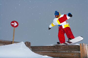 Snowboarder sliding on wooden fence