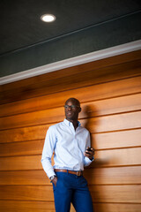 Fototapeta premium Businessman leaning on wooden wall