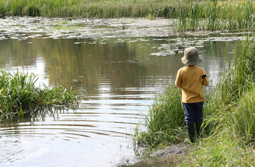 Fototapeta na wymiar Boy fishing on the river on a sunny autumn day