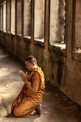 Obraz premium Young Buddhist monk praying in temple, Angkor Wat, Siem Reap, Cambodia