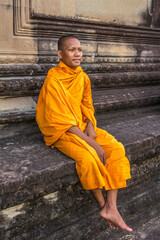 Fototapeta premium Young Buddhist monk sitting at temple in Angkor Wat, Siem Reap, Cambodia