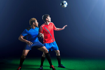 Male soccer players with ball mid air © Image Source Limited