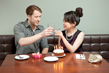 Young couple celebrating birthday in restaurant