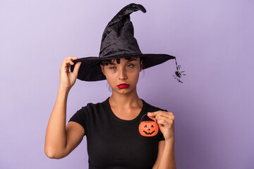 Young mixed race woman disguised as a witch isolated on purple background  being shocked, she has remembered important meeting.