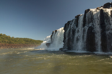 Sailing the river. The majestic Mocona waterfalls seen from the boat. The falling white water, rocks and river flowing across the jungle. 