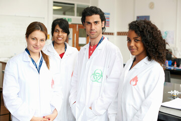 Portrait of four college students wearing lab coats