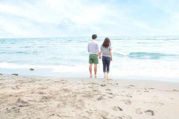 Fototapeta na wymiar Young couple holding hands beach