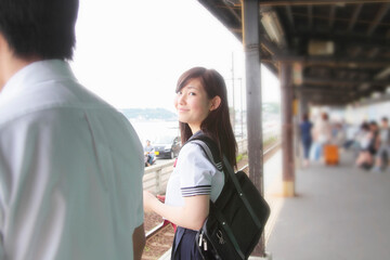 Young woman on railway platform looking at camera