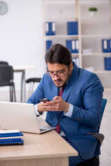 Fototapeta premium Young male employee sitting at workplace