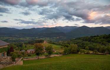 Fototapeta premium Sunset in a valley with mountains in the background