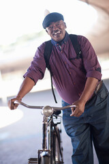 Senior man pushing bicycle through city underpass