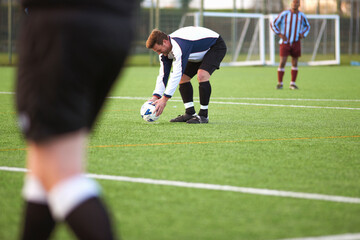 Football player positioning ball