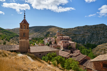 Fototapeta na wymiar View of an old town with a bell tower surrounded by mountains