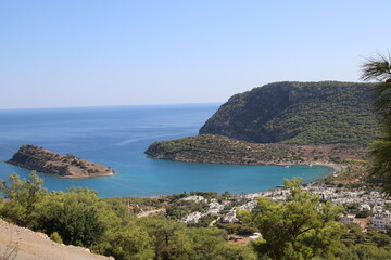 Bay and island view with hills and trees around it.