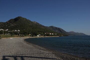 Mountain view coastline with forest, beach.