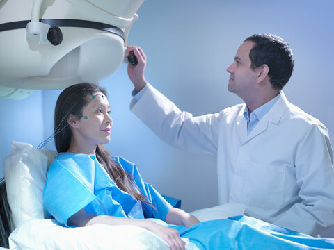 Doctor treating patient using magnetoencephalography (MEG) scanner