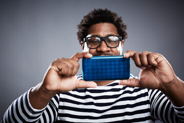 Studio portrait of mid adult man taking smartphone selfie