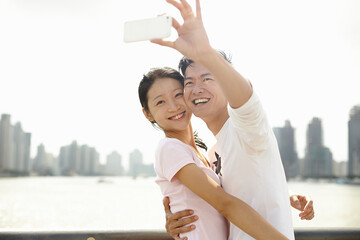 Tourist couple taking smartphone self portrait, The Bund, Shanghai, China