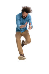 attractive casual man jumping, clapping his hands