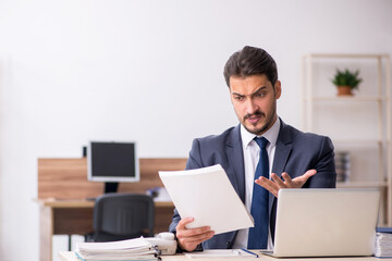 Young male employee sitting at workplace