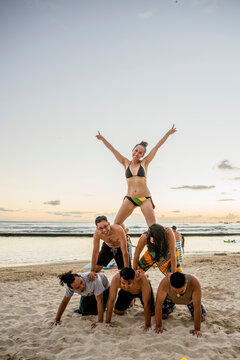 Six Adult Friends Forming Human Pyramid On Waikiki Beach, Hawaii, USA