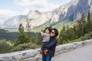 Fototapeta na wymiar Mature woman carrying granddaughter, Yosemite National Park, California, USA
