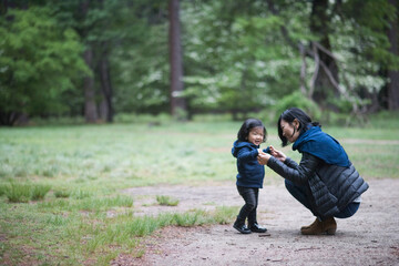 Fototapeta premium Mid adult woman crouching with toddler daughter on forest path, Yosemite National Park, California, USA