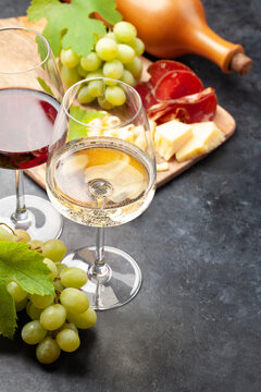 White and red wine glasses, grape and appetizer board