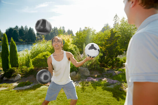 Man juggling balls in field