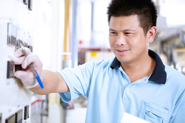 Man at control panel in flexible electronics plant