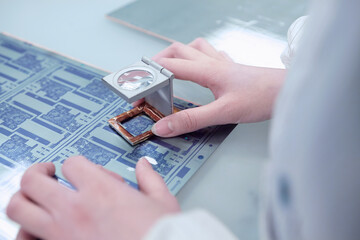 Hands of female worker inspecting flex circuit in flexible electronics factory - obrazy, fototapety, plakaty