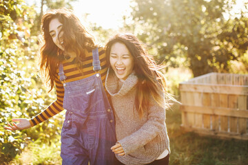 Two young women, in rural environment, laughing