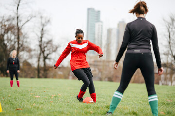 Female soccer player practicing with soccer in park © Image Source Limited