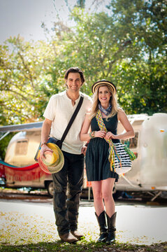 Portrait Of Couple In Front Of Converted Boutique Airstream Trailer