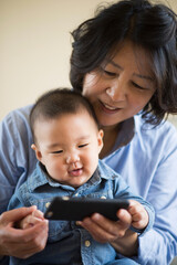 Grandmother showing smartphone to grandson