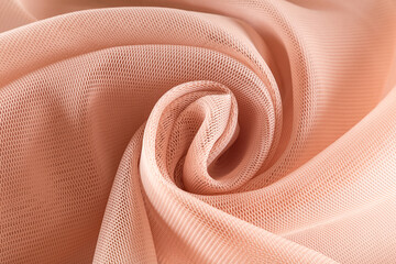 bright flesh-colored neoprene fabric coiled
