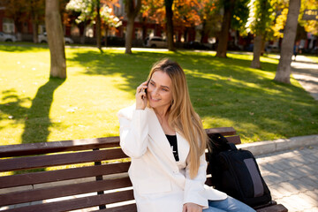 Young scandinavian blonde woman talking on mobile while sitting on a