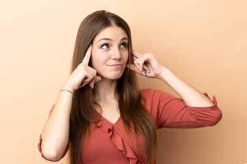 Obraz premium Young caucasian woman isolated on beige background having doubts and thinking