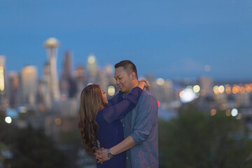 Couple hugging, city skyline in background