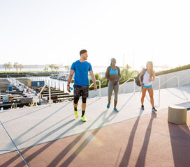 Obraz premium Man and two young women training, talking in sport facility, downtown San Diego, California, USA