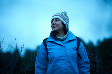 Female hiker hiking in forest at dusk