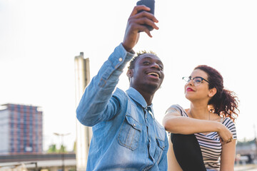 Couple using smartphone to take selfie, Milan, Italy