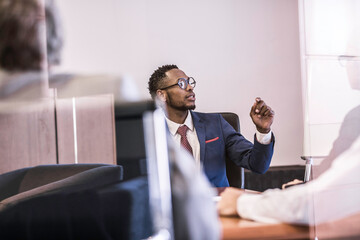 Window view of businessman questioning in board meeting - obrazy, fototapety, plakaty