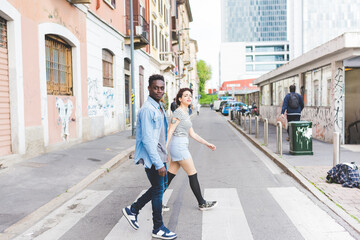 Couple walking across pedestrian crossing, Milan, Italy