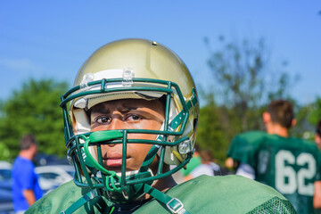 Portrait teenage male American football player wearing helmet at playing field © Image Source Limited