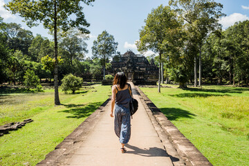 Fototapeta premium Rear view of woman in garden of Phimeanakas temple, Siem Reap, Cambodia
