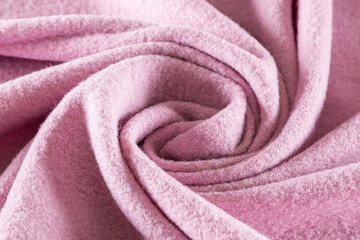 Fototapeta na wymiar rolled into a spiral warm coat fabric with a soft pink pile