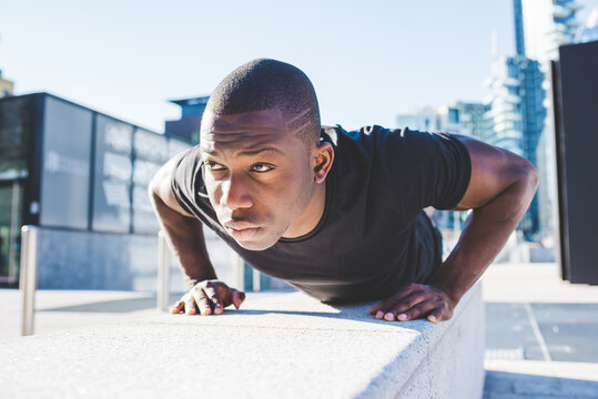 Young man exercising outdoors, doing push-ups